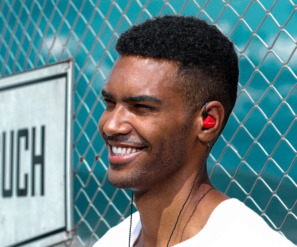 A joyful man uses a red TRN V20 earphone
