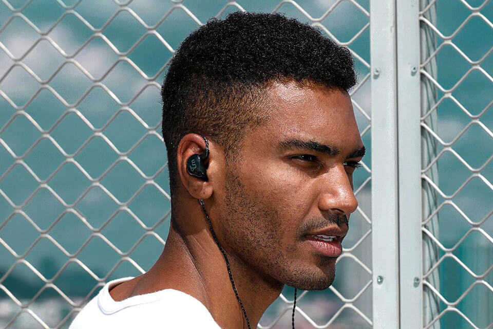 A man uses a glossy black TRN V10 earphone